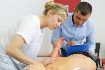 young lady using dummy on first aid training course