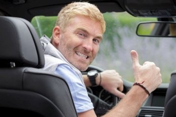 happy man driver in car or van on road trip