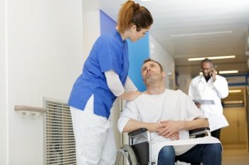 nurse reassuring patient in a wheelchair