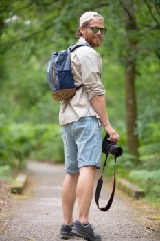 shot of young man hiker with backpack taking a photo