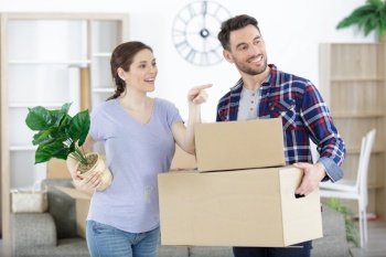 surprised couple entering in their new home with moving box