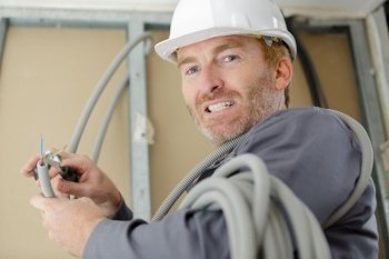 a happy electrician connecting wires