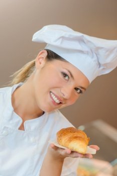 Bakery worker holding a croissant