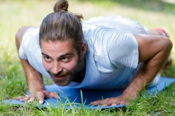 man in plank exercise position on mat outdoors