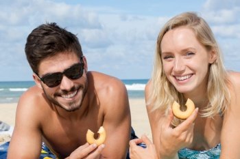 couple in love sharing food on the beach
