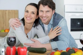 cute couple hugging with vegetables on wooden table