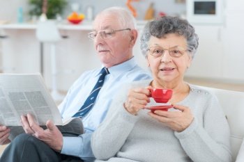 senior couple reading newspaper together at home