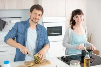 happy heterosexual couple cooking together
