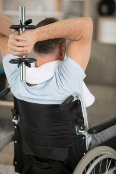 handicapped man on wheelchair working out with dumbbell