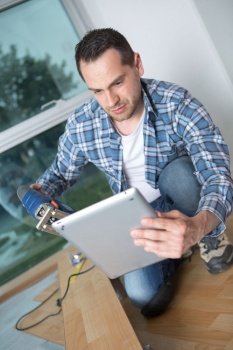 Man doing DIY and looking at tablet screen