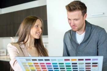 couple choosing paint swatch for new home