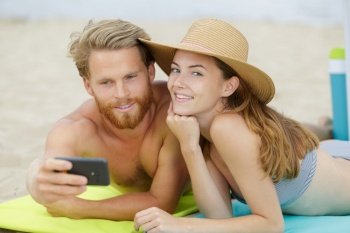 couple taking selfie on beach woman looking to camera