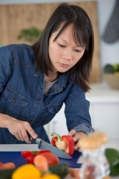 woman cutting a tomato on the cut board