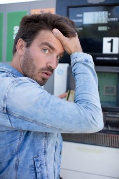 shocked man counting money with gasoline refueling car