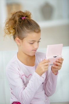 Girl playing electronic device, frustrated expression