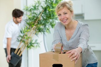 woman closing boxes to move to her new house