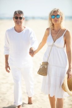lovely senior mature couple walking happy and relaxed on beach