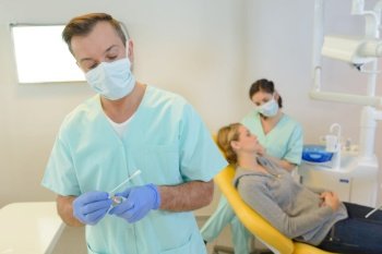 dentist curing a woman patient in the dental office