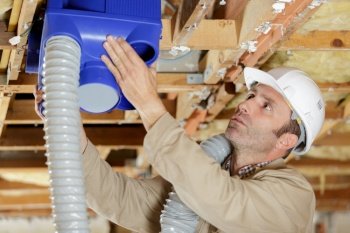 close up of a man fitting aircondition pipes