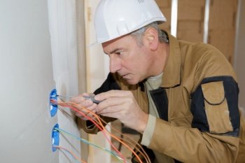 Senior electrician concentrating on wiring