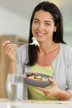 beautiful woman with salad on interior background