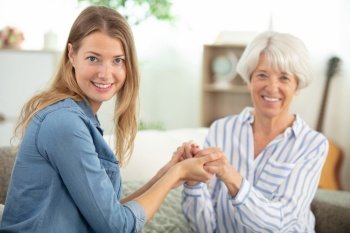 cheerful mature woman embracing senior mother at home