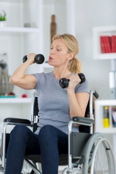 happy handicapped person on a wheelchair with a dumbbell