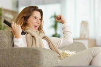 exited woman with remote control and popcorn