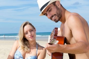 couple with guitar on the sea