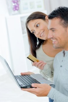 couple with laptop and bank card