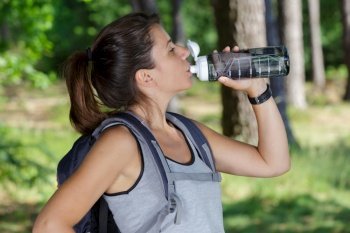 hiker woman drinking water outdoors