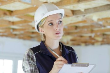woman builder writing on clipboard