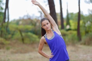 young woman stretching arms outdoors