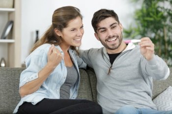 happy couple looking pregnancy test