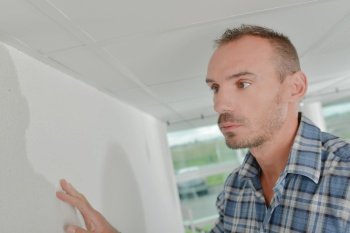 man checks the wall in the room of new house