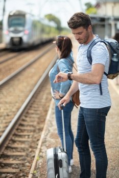 couple is traveling and waiting train on platform