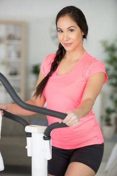 beautiful young woman exercising on stepper at home