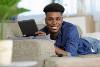 young man with tablet relaxing on the sofa
