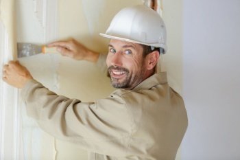 contractor employee applying plaster on wall