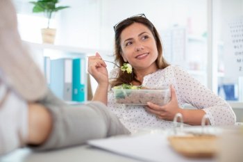 woman eating healthy business lunch in modern office