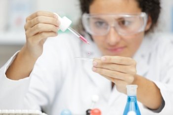 young woman in scientific lab with pipette
