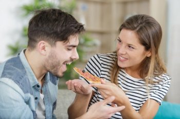 young hipster male and female couple home eating pizza