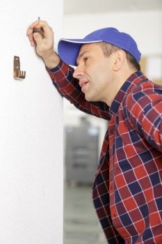 middle age electrician performs electrical work