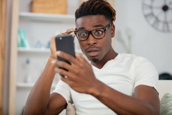 surprised happy african man holding phone