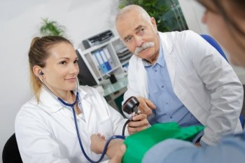 doctors measuring patients blood pressure