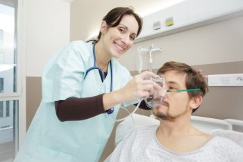 happy nurse placing oxygen mask on patient