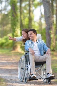 young couple in wheelchair checking the directions