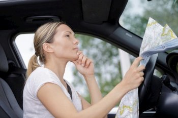 young woman planning a road trip vacation using a map