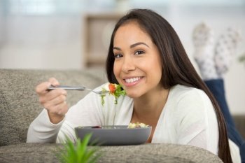 happy woman eating salad at home