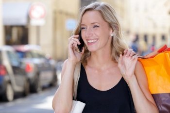 attractive woman happy with the shopping bags on the phone